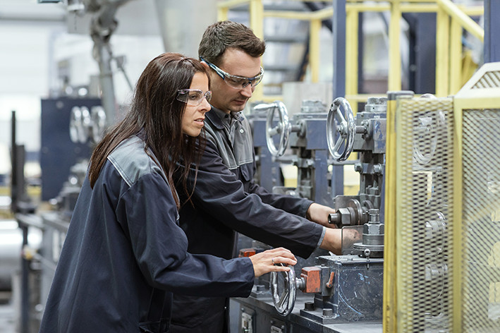 Two employees of voestalpine working on a machine.