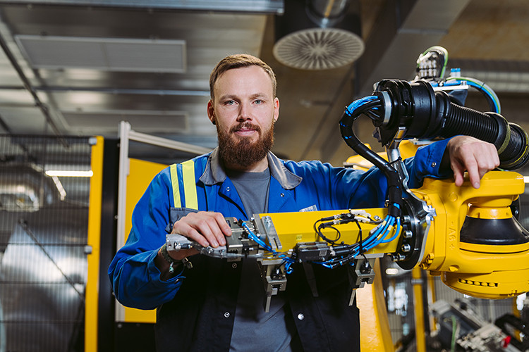 Florian arbeitet mit verschieden Maschinen und Robotern im neuen voestalpine Prüfzentrum in Linz.