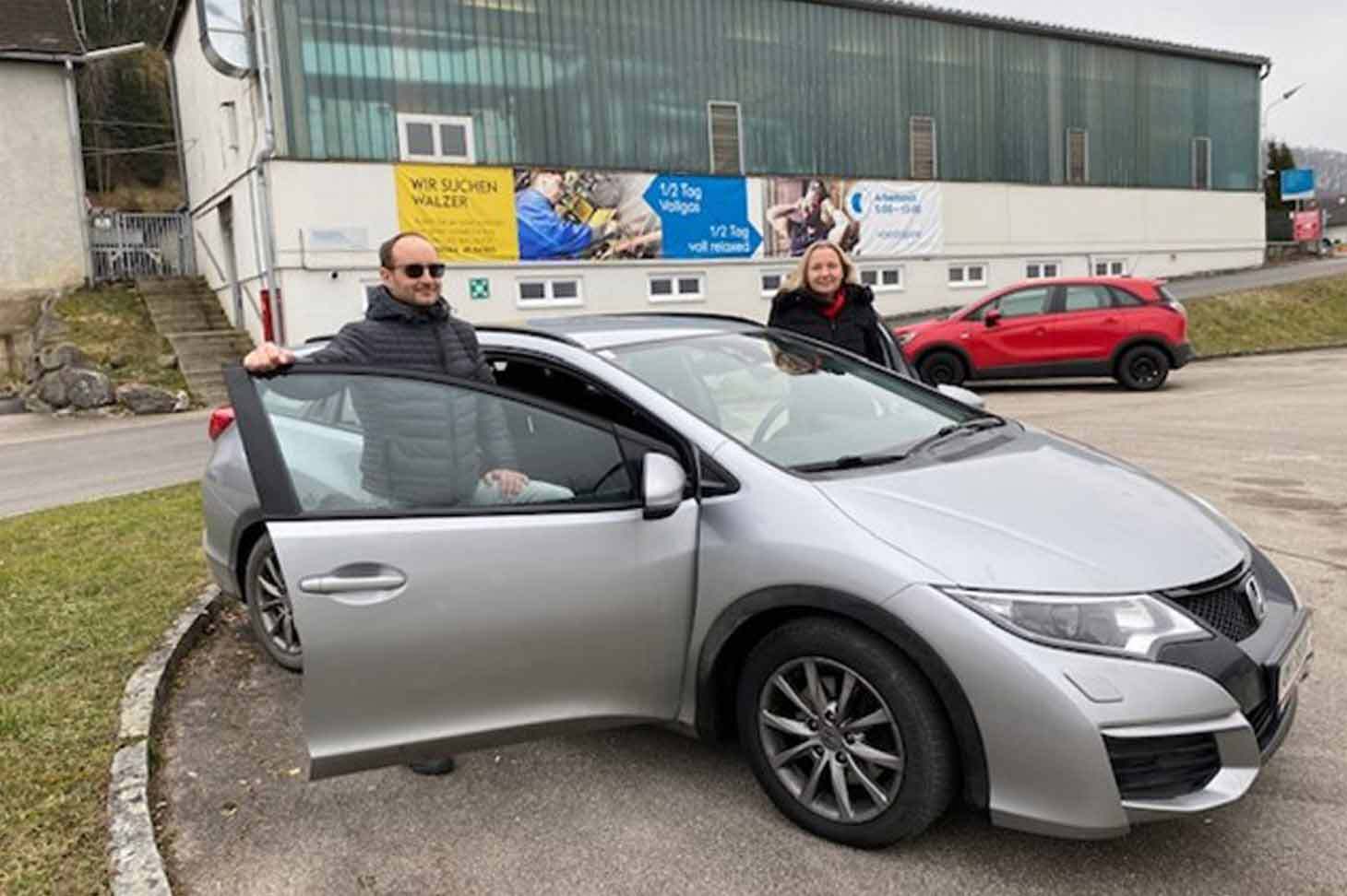 An employee of voestalpine gets into an electric car