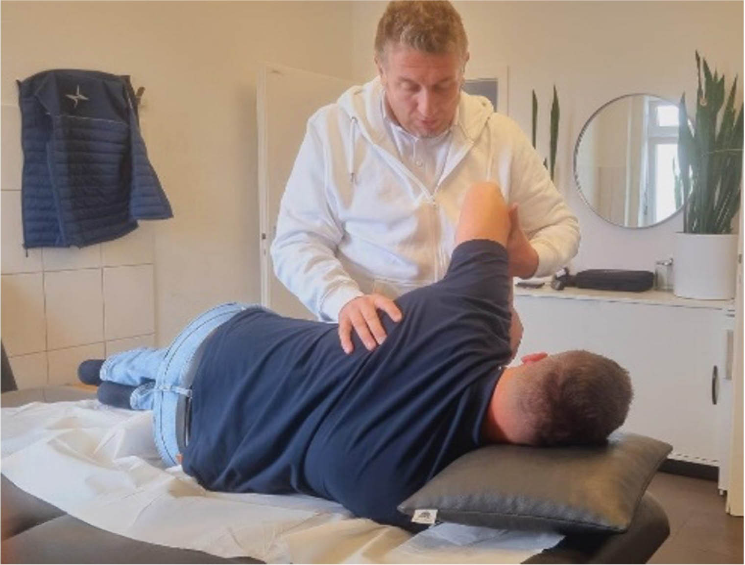 Der Physiotherapeut behandelt den Patienten auf der Liege.