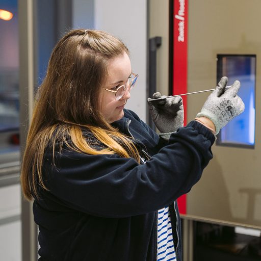voestalpine employee Anna holds a steel part for testing