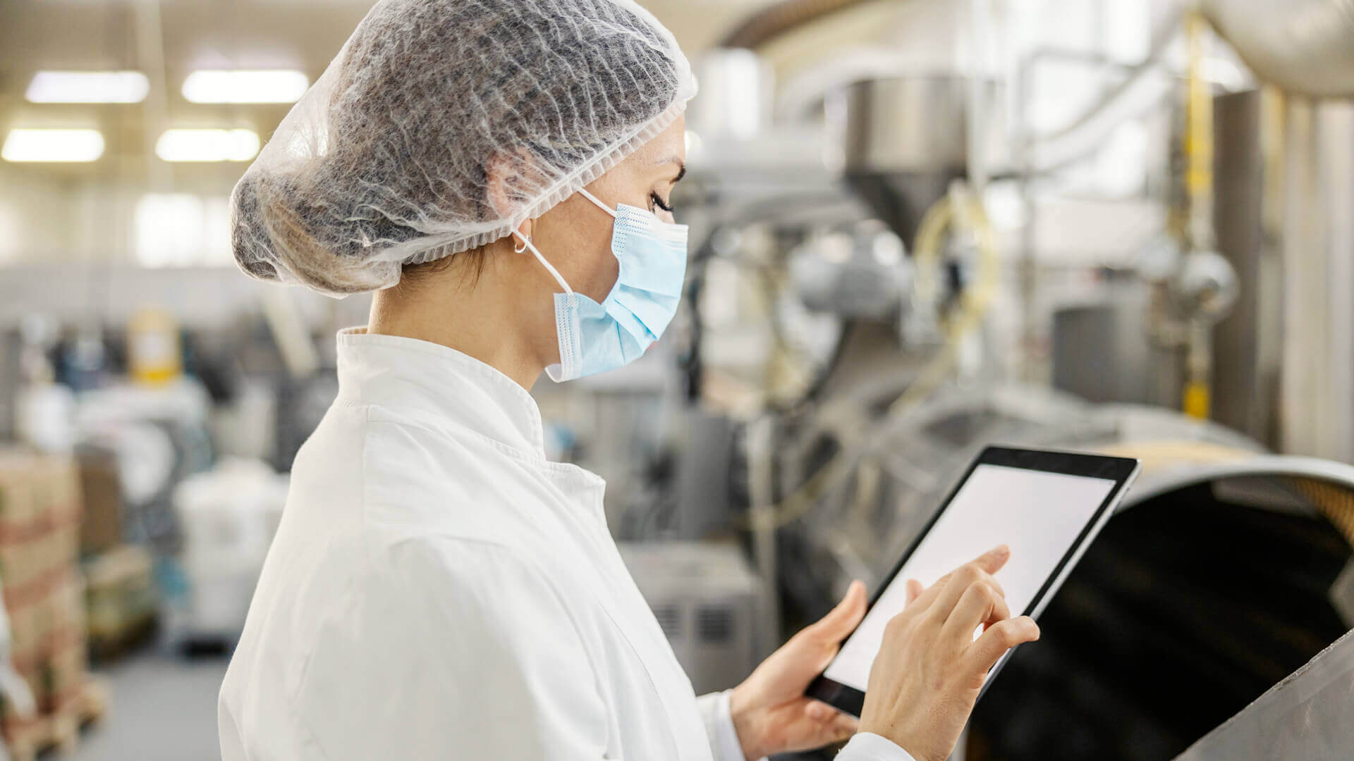 a woman in safety gear looking at a tablet