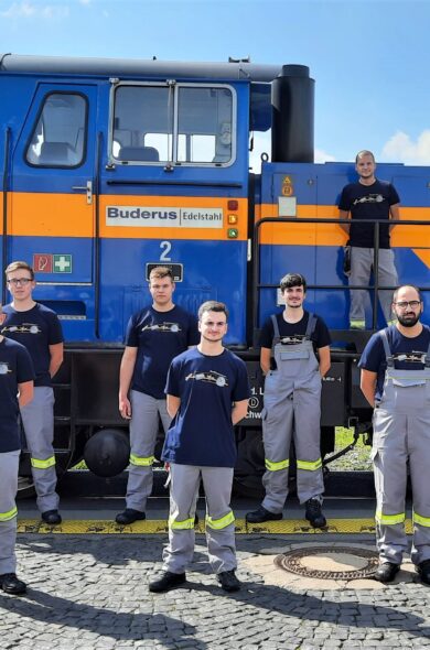 Teamfoto von Mitarbeitern vor einem Zug