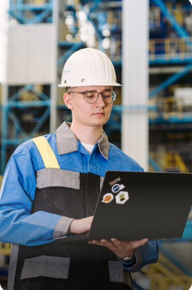 Lehrling mit Laptop in der Werkstatt