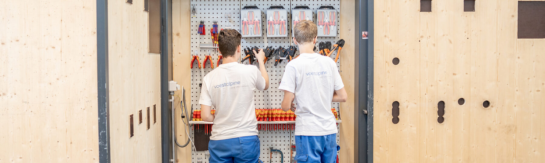 Lehrlinge vor Werkzeugschrank