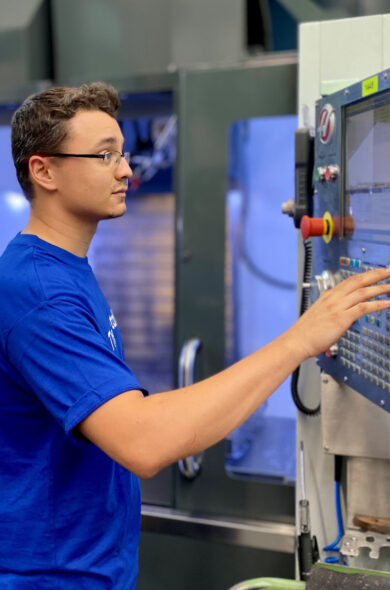 Lehrling vor CNC Maschine