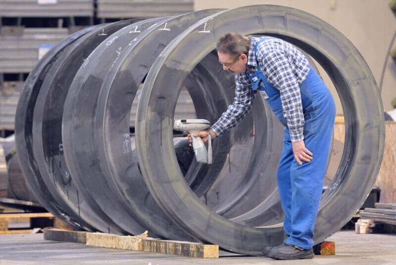 steel plant worker examining a steel ring manufactured for the energy sector